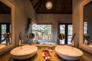 ein Badezimmer mit zwei Waschbecken und zwei Spiegeln in der Unterkunft Naledi Lodges in Balule Game Reserve