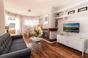 salon z kanapą i kominkiem w obiekcie Pueblo Doña Pepa w mieście Torremuelle