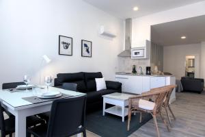 a living room and kitchen with a table and a couch at Hotel Apartamentos MPD in Merida