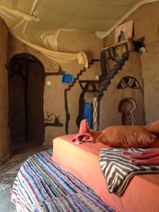 1 dormitorio con 1 cama y una casa pintada en la pared en Maison Boutchrafine en Erfoud