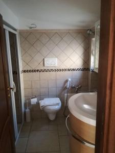 a small bathroom with a toilet and a sink at Trulli dell'aia in Alberobello