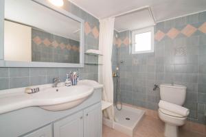 a bathroom with a sink and a toilet and a mirror at Villa Iliogenniti in Kalamaki +19 photos