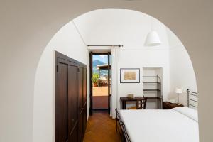 a bedroom with two beds and an arched doorway at Albergo Il Monastero in Ischia