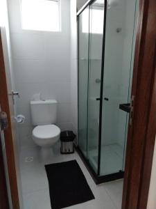 a bathroom with a toilet and a glass shower at Essencial Manaíra in João Pessoa