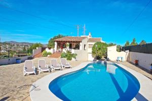 ein Swimmingpool mit Stühlen und ein Haus in der Unterkunft El Ventorrillo - holiday home with stunning views and private pool in Benissa in Benissa