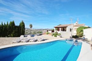 ein Swimmingpool mit Stühlen und ein Haus in der Unterkunft El Ventorrillo - holiday home with stunning views and private pool in Benissa in Benissa