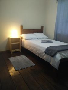 um quarto com uma cama e uma mesa de cabeceira com um candeeiro em Casa Chayito em Santa María