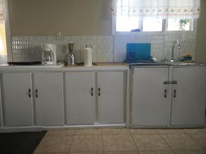 a kitchen with white cabinets and a sink at Casa Chayito in Santa María