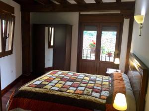 a bedroom with a bed with a quilt on it at La Casuca de Pumareña in Pumareña