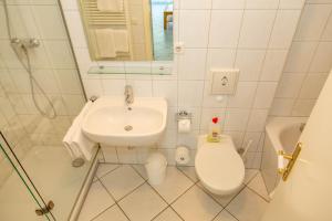 a white bathroom with a toilet and a sink at Apartment Astra mit 2 Balkone in Zempin +51 photos