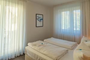 a bedroom with two beds and two windows at Apartment Astra mit 2 Balkone in Zempin