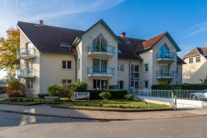 una grande casa bianca con balconi su una strada di Apartment Astra a Zempin