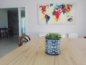 a planter sitting on a wooden table with a painting at Villa Clarita Tandil in Tandil