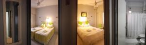 1 dormitorio con 2 camas y 2 lámparas en Noria Hotel en Villa Carlos Paz