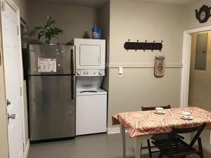 a kitchen with a refrigerator and a table with a tablecloth at Modern 3/1 house close to Beaches and Midtown in Miami