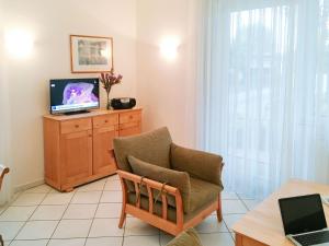 岑平的住宿－Apartment Fridolin，客厅配有椅子和电视