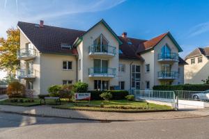 a large white house with balconies on a street at Apartment Helena mit 2 Terrassen in Zempin