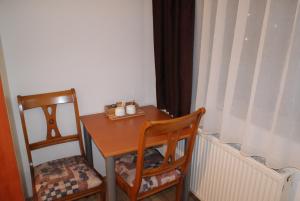 mały stolik z dwoma krzesłami i stół z grzejnikiem w obiekcie Vila Sorina w mieście Poiana Brașov