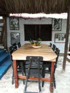 un tavolo di legno con sedie e una ciotola di frutta sopra di Hostel Cattleya a Palomino