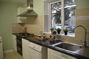 a kitchen with a sink and a window and a stove at The Spinney in Bracknell