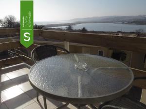 a glass table on a balcony with a view at Riomar Apart Hotel in Concón