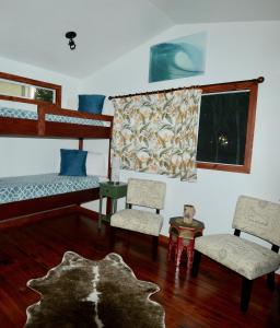 a bedroom with two bunk beds and two chairs at Kalani Hawaii Private Lodging in Pupukea