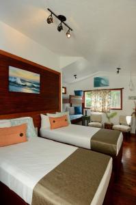 a bedroom with two beds and a living room at Kalani Hawaii Private Lodging in Pupukea