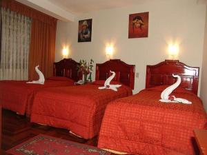 Una habitación de hotel con dos camas con cisnes. en Hotel Inkayra, en Cusco