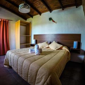 a bedroom with a large bed in a room at Cabañas & Suites Vista Hermosa in Los Reartes