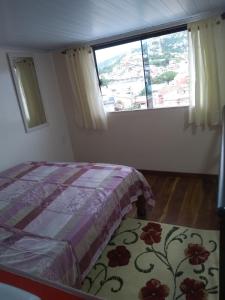 1 dormitorio con cama y ventana grande en Apto praia grande ph2, en Arraial do Cabo