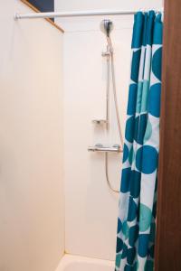ducha con cortina azul y blanca en House of Magic, en Amberes