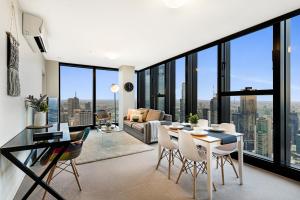 a living room with a table and chairs and a large window at Studio# on Collins in Melbourne