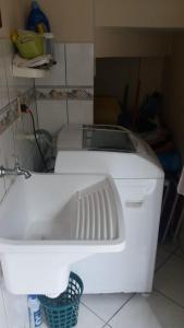 a kitchen with a white sink in a room at Apartamento Bombinhas in Bombinhas