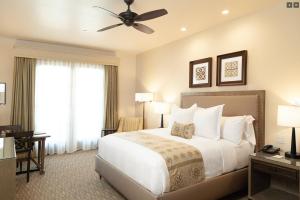 a bedroom with a large bed with a ceiling fan at Ponte Vineyard Inn in Temecula