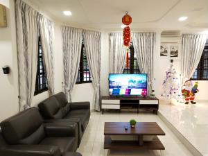 een woonkamer met een televisie en een kerstboom bij Ipoh TG Signature in Ipoh