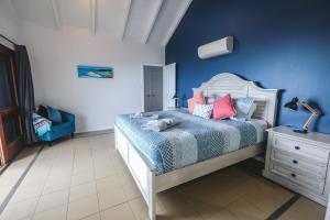 a bedroom with a bed and a blue wall at Absolute Airlie in Airlie Beach