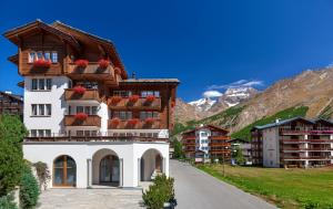 a building with flowers on the balconies on a street at Arcade Apartments & Spa in Saas-Fee