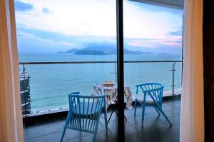 d'une table et de chaises sur un balcon avec vue sur l'océan. dans l'établissement Holi Beach Hotel & Apartments, à Nha Trang
