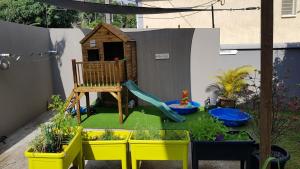 a miniature garden with a play set and a playground at T2 avec accès piscine SUD- OUEST de la Réunion in Les Cocos