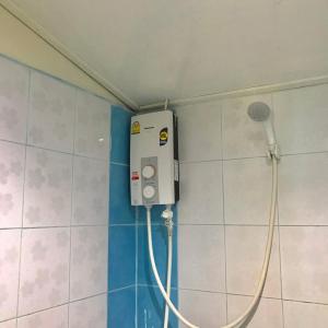 La salle de bains est pourvue d'une douche et d'un tuyau fixé au mur. dans l'établissement Libong Beach Resort, à Ko Libong