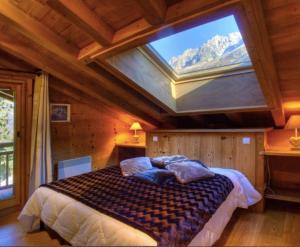 a bedroom with a bed with a large window at CHALET CHAM'ROCK in Les Houches