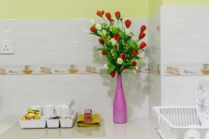 
a vase filled with flowers sitting on a counter top at TOURIST INN in Male City
