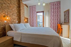 a bedroom with a bed and a brick wall at Akrathos Houses in Polychrono +36 photos