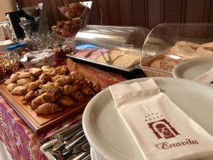 a table topped with plates of bread and pastries at Hotel Epavlis in Drama