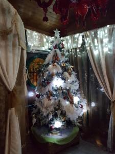 a white christmas tree in a room with curtains at B&B Marilena affittacamere in Rocca Imperiale
