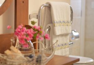 a bathroom sink with a basket of flowers and towels at Villa Te Soro Bed and breakfast in Auckland