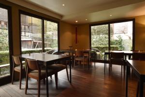 - un restaurant avec des tables, des chaises et de grandes fenêtres dans l'établissement Yadoya Nishijinso, à Kyoto