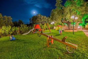 a park with playground equipment in the grass at night at Akrathos Houses in Polychrono