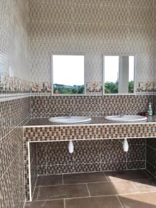 a bathroom with three sinks and two windows at Aneeda Inn in Pantai Cenang