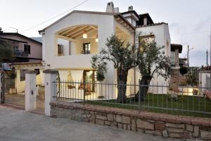 a white house with a fence in front of it at GRECALE a pochi passi dal mare in Santa Maria Navarrese